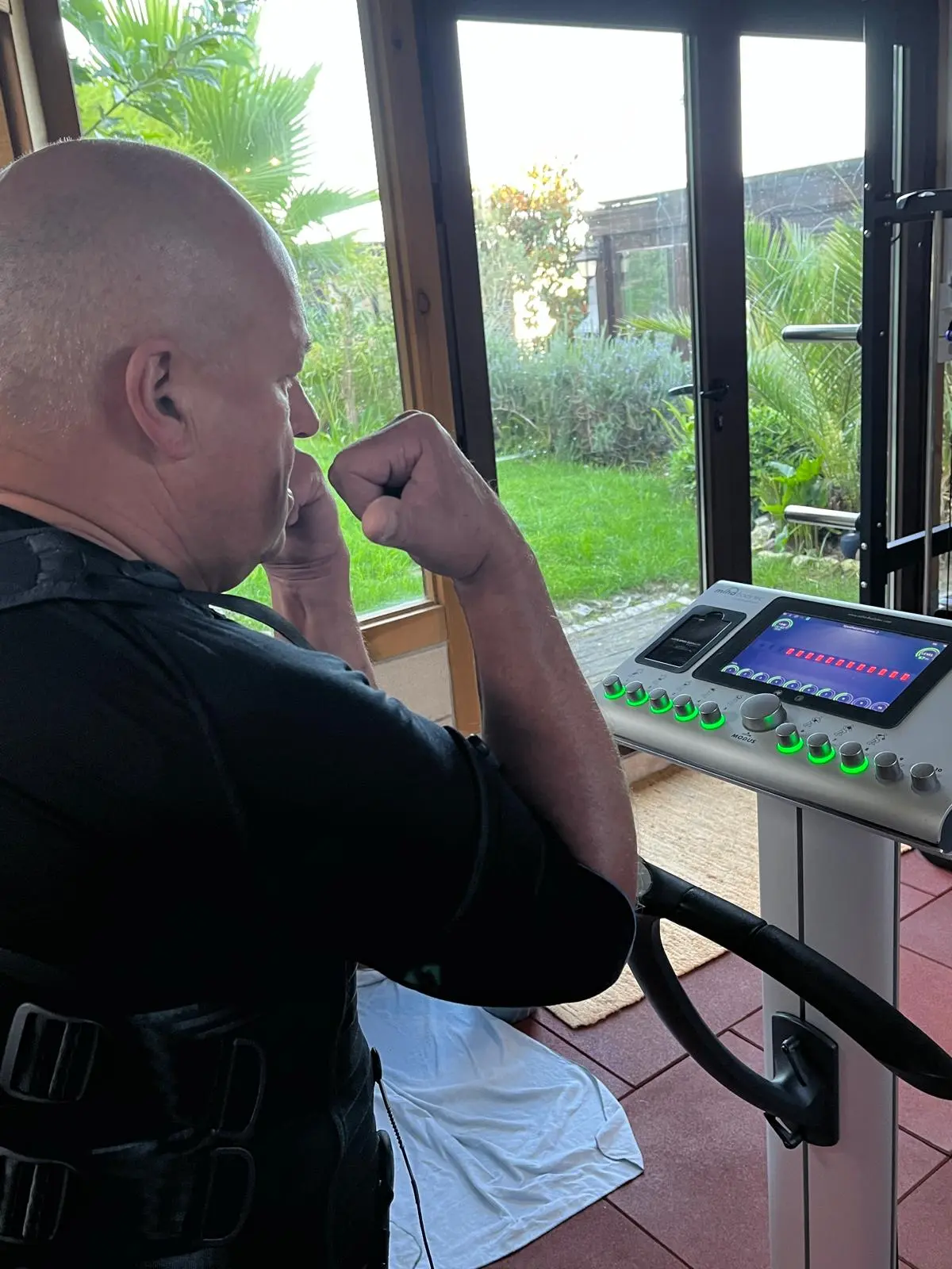 Person absolviert geführtes EMS-Training mit einem Personal Trainer während des Urlaubs in Portugal.